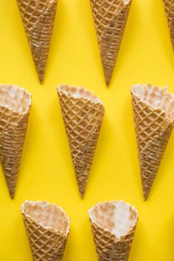 Parlak sarı arka planda boş waffle gofret dondurma koni