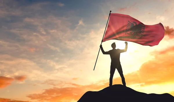 Bandera de Albania ondeada por un hombre que celebra el éxito en la cima — Foto de Stock