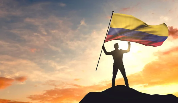 Bandera de Colombia ondeada por un hombre celebrando el éxito en el — Foto de Stock