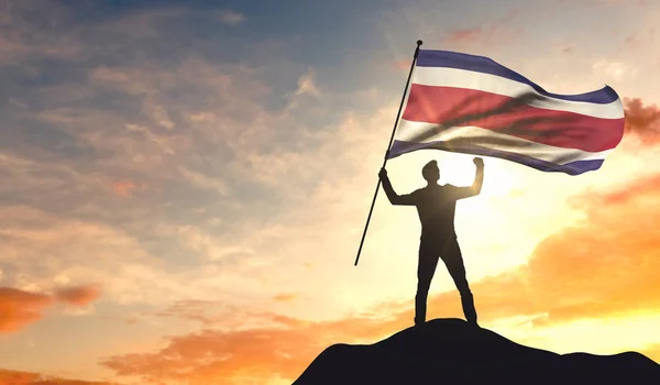 Флагом Коста-Рики размахивает человек, празднующий успех на — стоковое фото