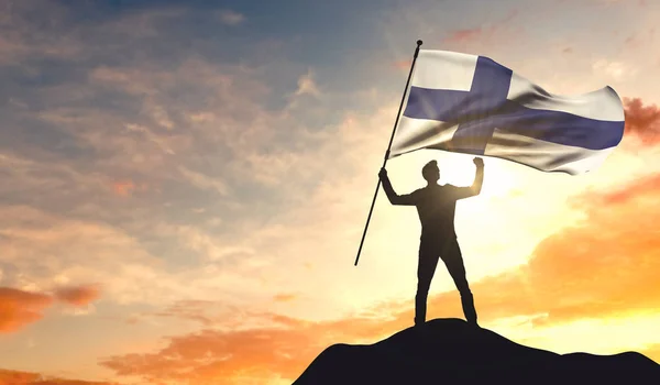 Bandera de Finlandia ondeada por un hombre que celebra el éxito en la cima — Foto de Stock