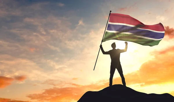 冈比亚国旗被一个人挥舞着,庆祝在顶部的成功 — 图库照片