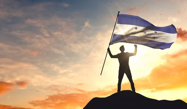 Honduras flag being waved by a man celebrating success at the to — Stock Photo, Image