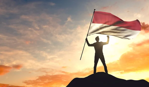 Bandeira da Indonésia sendo acenada por um homem comemorando o sucesso no t — Fotografia de Stock