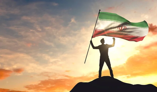 Iranische Flagge, die von einem Mann geschwenkt wird, der an der Spitze des — Stockfoto