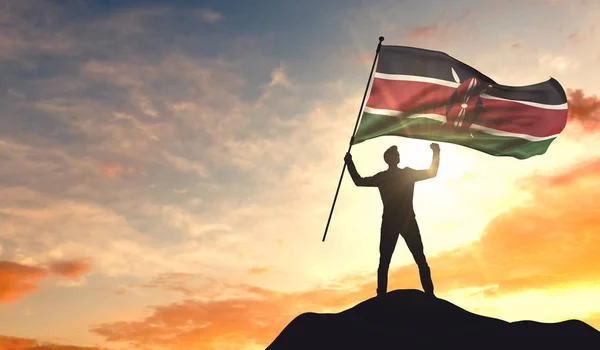 Bandiera del Kenya sventolato da un uomo che celebra il successo nella parte superiore o — Foto Stock