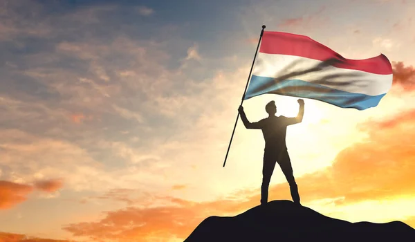 Bandeira do Luxemburgo sendo acenada por um homem comemorando o sucesso no — Fotografia de Stock