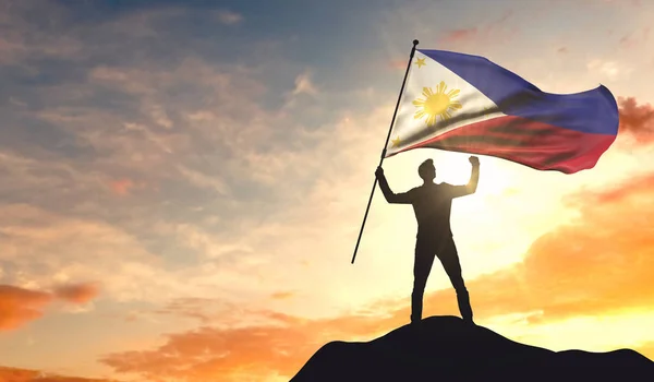 La bandera de Filipinas ondeada por un hombre que celebra el éxito en el —  Fotos de Stock