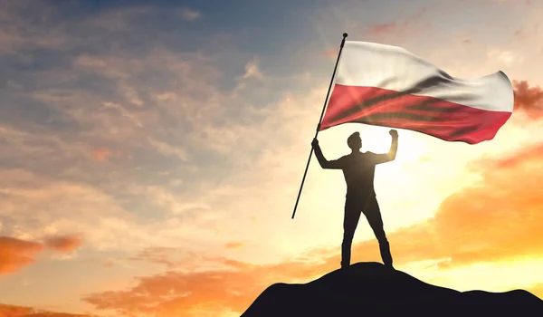 Bandeira da Polônia sendo acenada por um homem celebrando o sucesso no topo — Fotografia de Stock