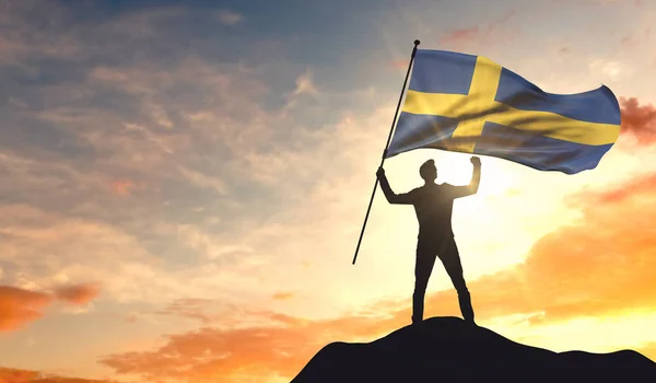 Svezia bandiera sventolata da un uomo che celebra il successo in cima — Foto Stock