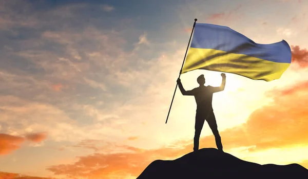 Флаг Украины размахивает человеком, празднующим успех на вершине