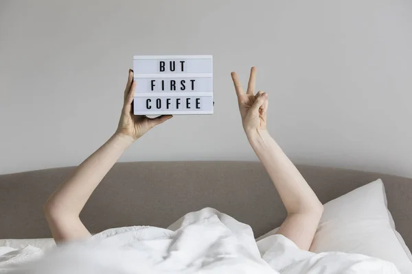 Mujer en la cama debajo de las sábanas sosteniendo un pero primer sig café — Foto de Stock