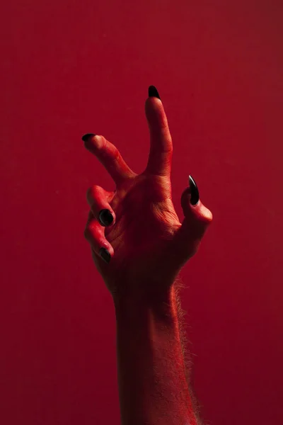 Halloween rode duivel monster hand met zwarte nagels tegen — Stockfoto