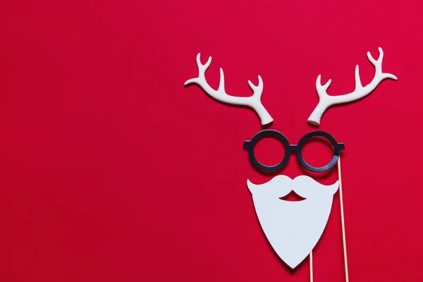 Cara de Navidad hecha de cornamentas blancas gafas y barba en una re —  Fotos de Stock