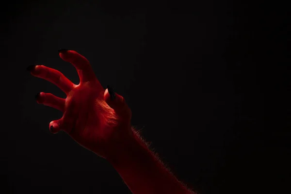 Red devil creepy halloween hand on a black background