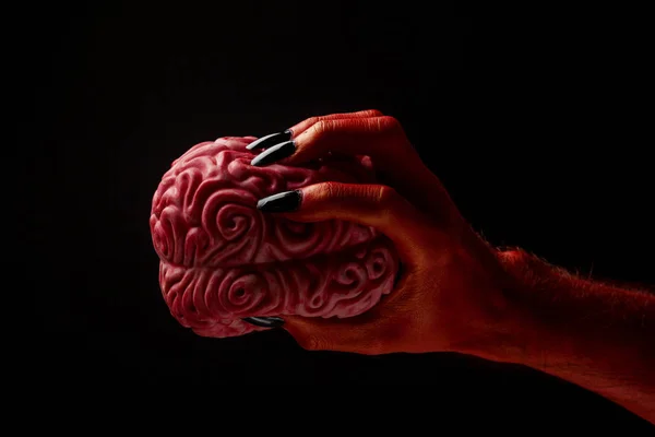 Mano roja del diablo sosteniendo un cerebro humano. Concepto Halloween — Foto de Stock