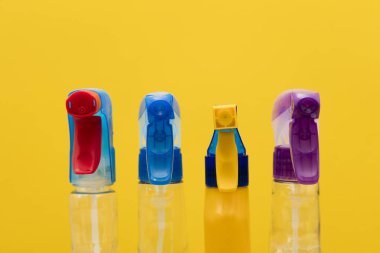 Parlak sarı arka planda sprey şişesi ürünlerini Temizleme