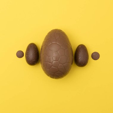 Parlak sarı arka planda çikolata Paskalya yumurtası. Paskalya Holi