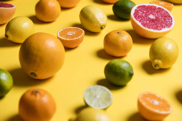 Citrus fuits, grapefruit, lemon, lime, orange on a yellow backgr