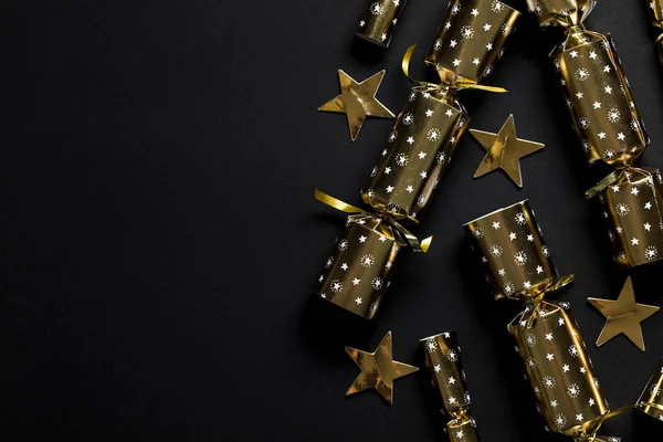 Gold festive Christmas crackers on a dark background — Stock Photo, Image