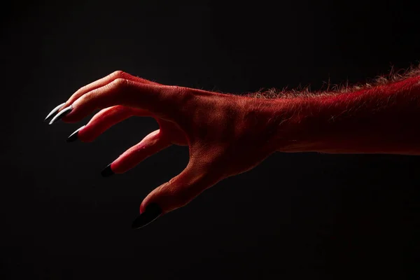 Diabo vermelho assustador halloween mão em um fundo preto — Fotografia de Stock