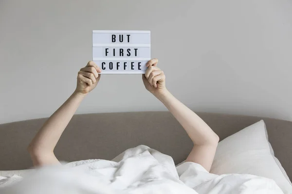 Mujer en la cama debajo de las sábanas sosteniendo un pero primer sig café — Foto de Stock