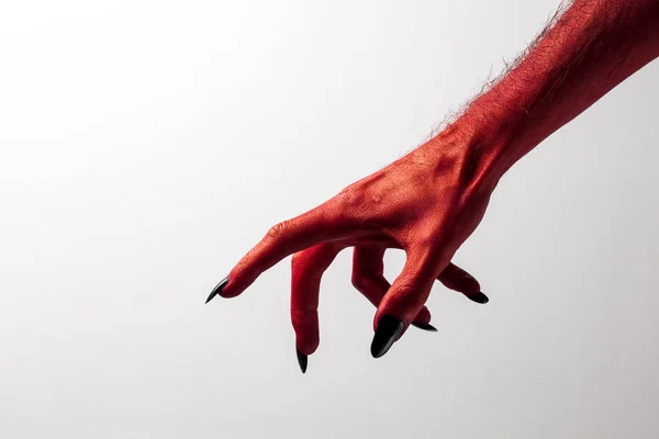 Halloween red devil monster hand with black fingernails against — Stock Photo, Image