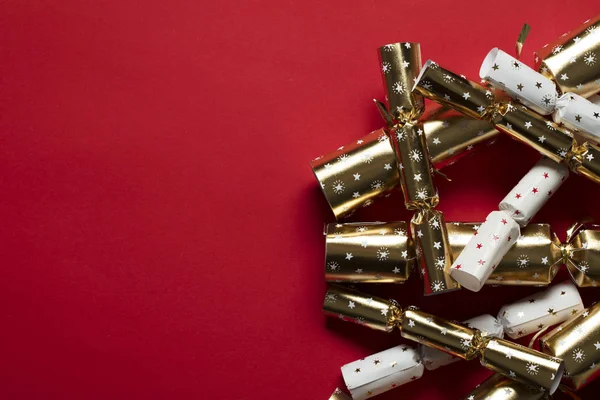 Festive Christmas crackers on a bright red background Royalty Free Stock Photos