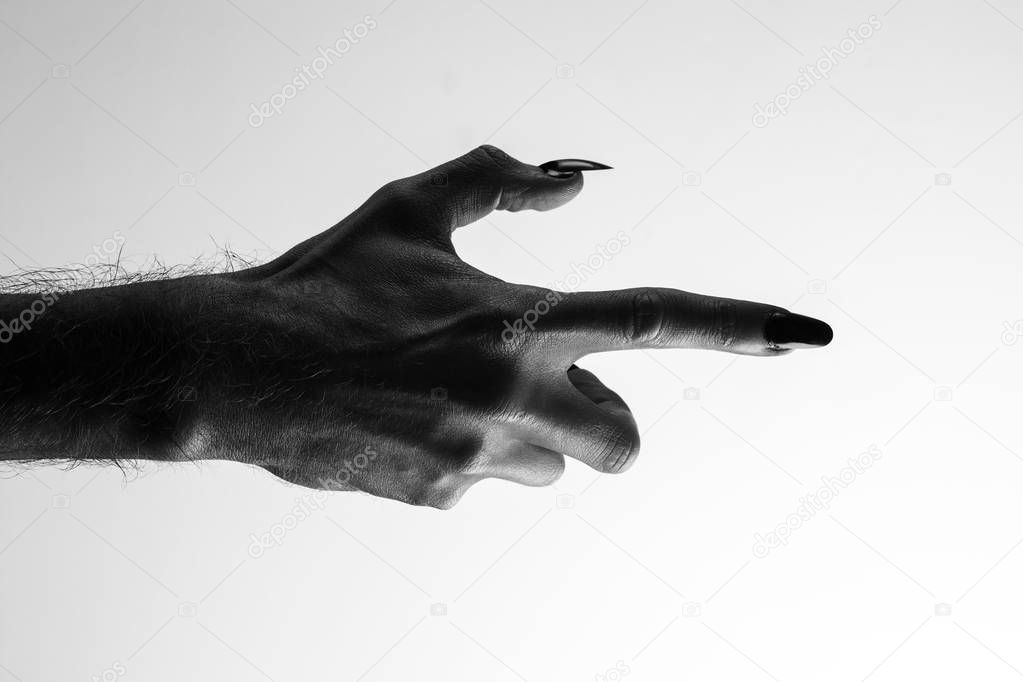 Black creepy halloween monster hand with long nails