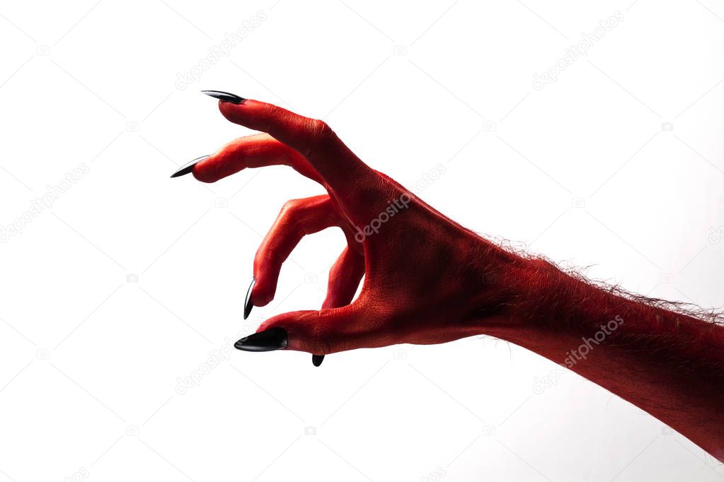 Halloween red devil monster hand with black fingernails against 