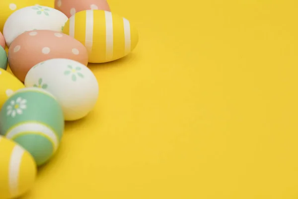 Malovaná velikonoční vajíčka na jasně žlutém pozadí — Stock fotografie