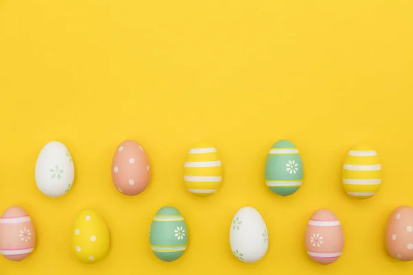 Parlak sarı bir arka plan üzerinde boyalı paskalya yumurtaları — Stok fotoğraf