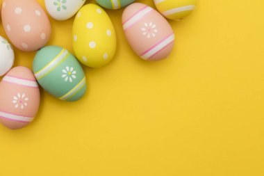 Parlak sarı bir arka plan üzerinde boyalı paskalya yumurtaları