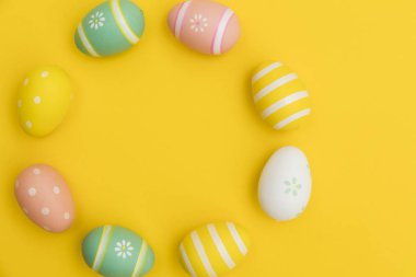 Parlak sarı bir arka plan üzerinde boyalı paskalya yumurtaları