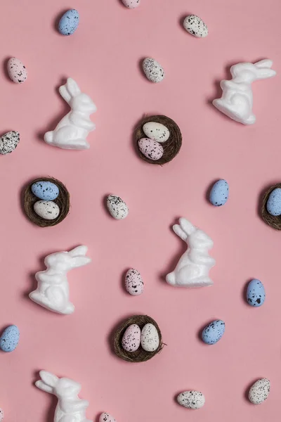 Easter background with easter eggs and easter bunnies on a pink