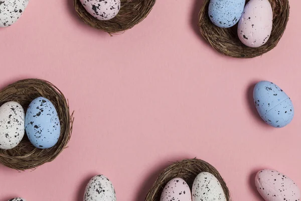 Ovos de Páscoa em um ninho em um fundo rosa pastel — Fotografia de Stock