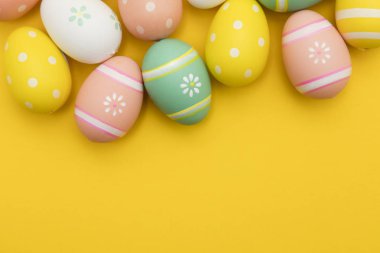 Parlak sarı bir arka plan üzerinde boyalı paskalya yumurtaları