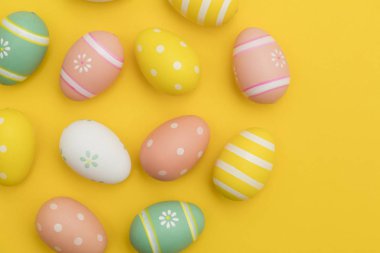 Parlak sarı bir arka plan üzerinde boyalı paskalya yumurtaları