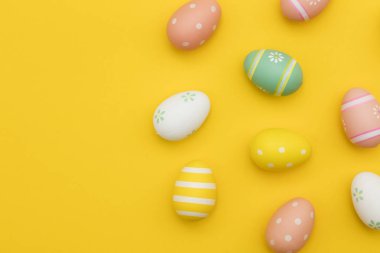 Parlak sarı bir arka plan üzerinde boyalı paskalya yumurtaları