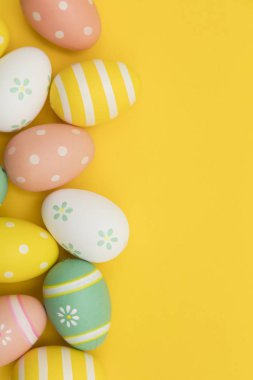 Parlak sarı bir arka plan üzerinde boyalı paskalya yumurtaları