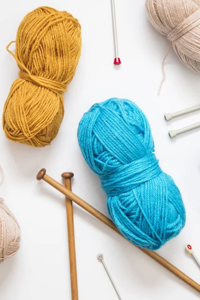 Knitting background. Balls of wool and knitting needles on a pla — Stock Photo, Image