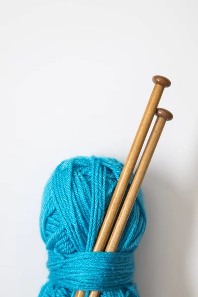 A ball of turquoise blue wool with wooden knitting needles — Stock Photo, Image