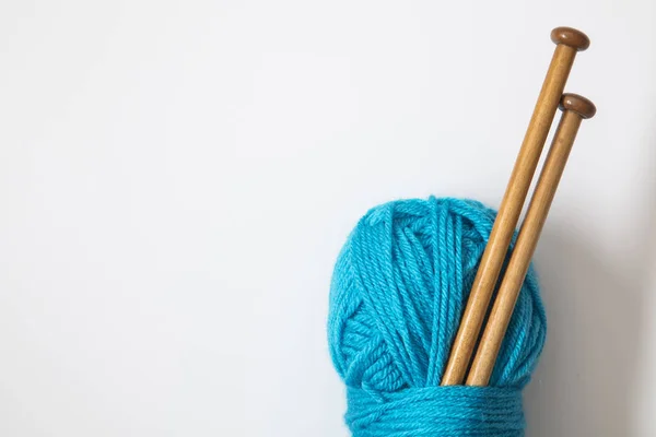 A ball of turquoise blue wool with wooden knitting needles — Stock Photo, Image