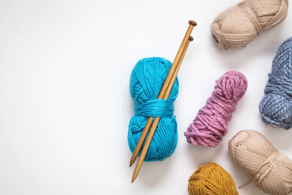 Knitting background. Balls of wool and knitting needles on a pla — Stock Photo, Image