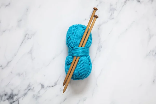 Een bal van turquoise blauwe wol met houten breinaalden — Stockfoto