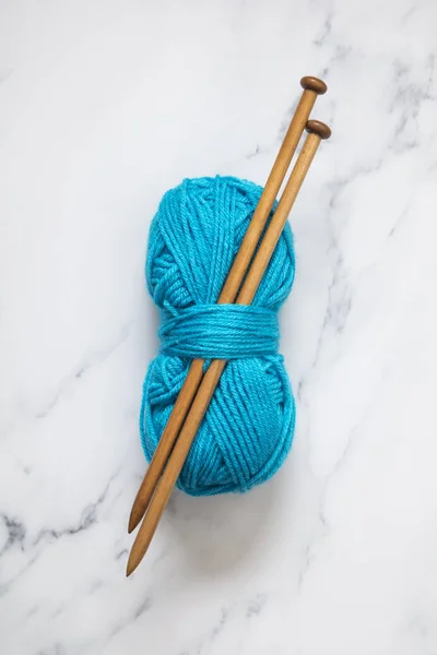 En boll av turkos blå ull med trä sticknålar — Stockfoto