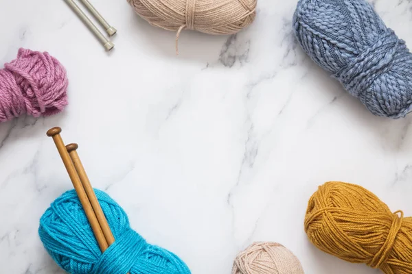 Knitting background. Balls of wool and knitting needles on a pla — Stock Photo, Image