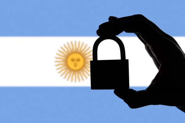 Argentina security. Silhouette of hand holding a padlock over na — Stock Photo, Image
