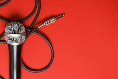 parlak kırmızı arka planda mikrofon ve kurşun.