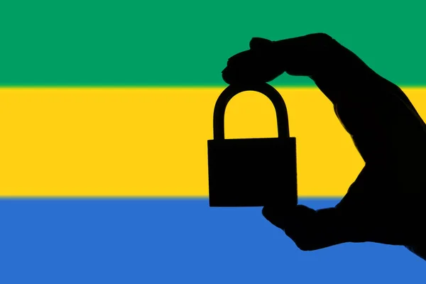 Gabon security. Silhouette of hand holding a padlock over nation — Stock Photo, Image
